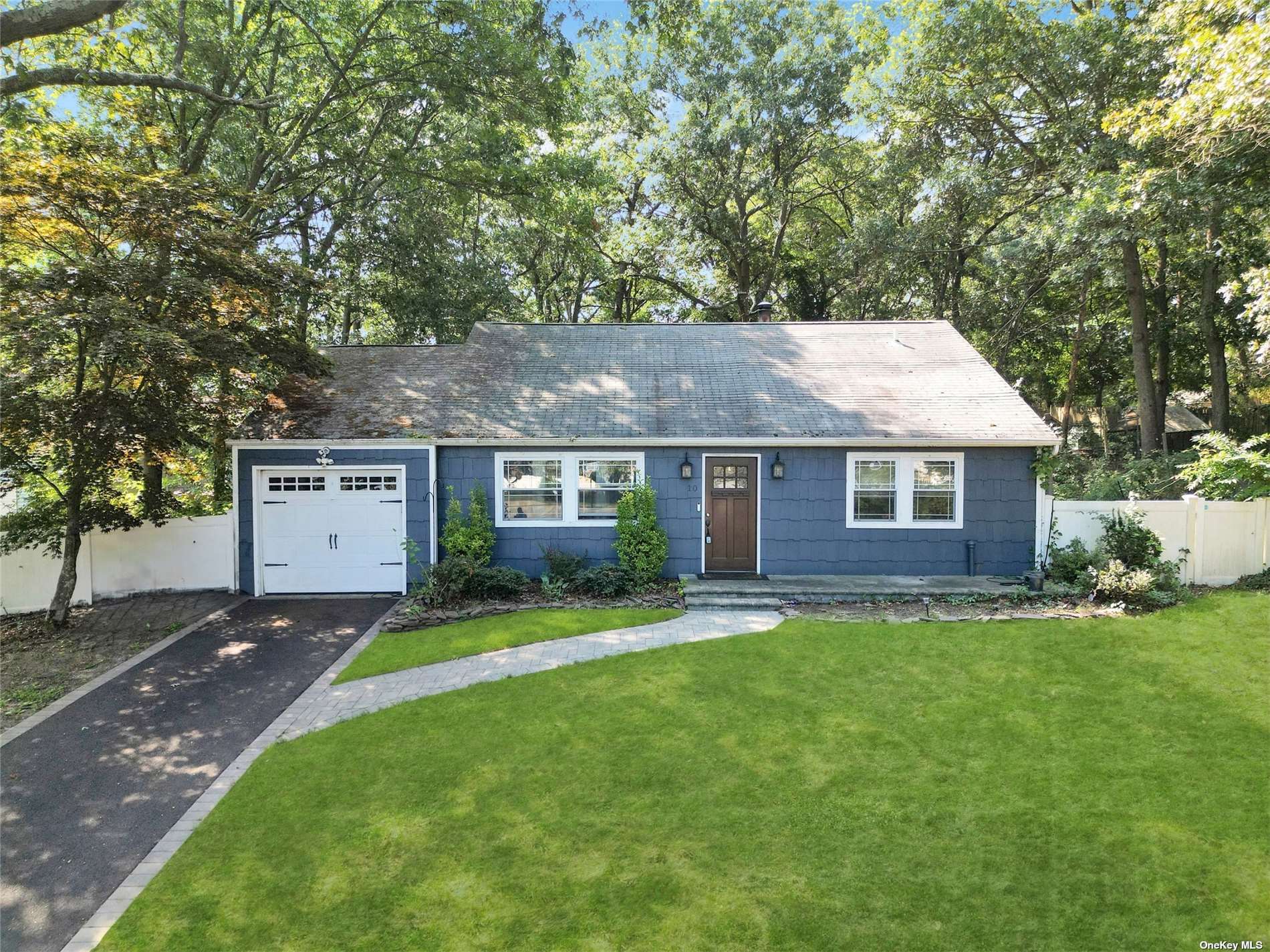 a front view of a house with a yard and trees