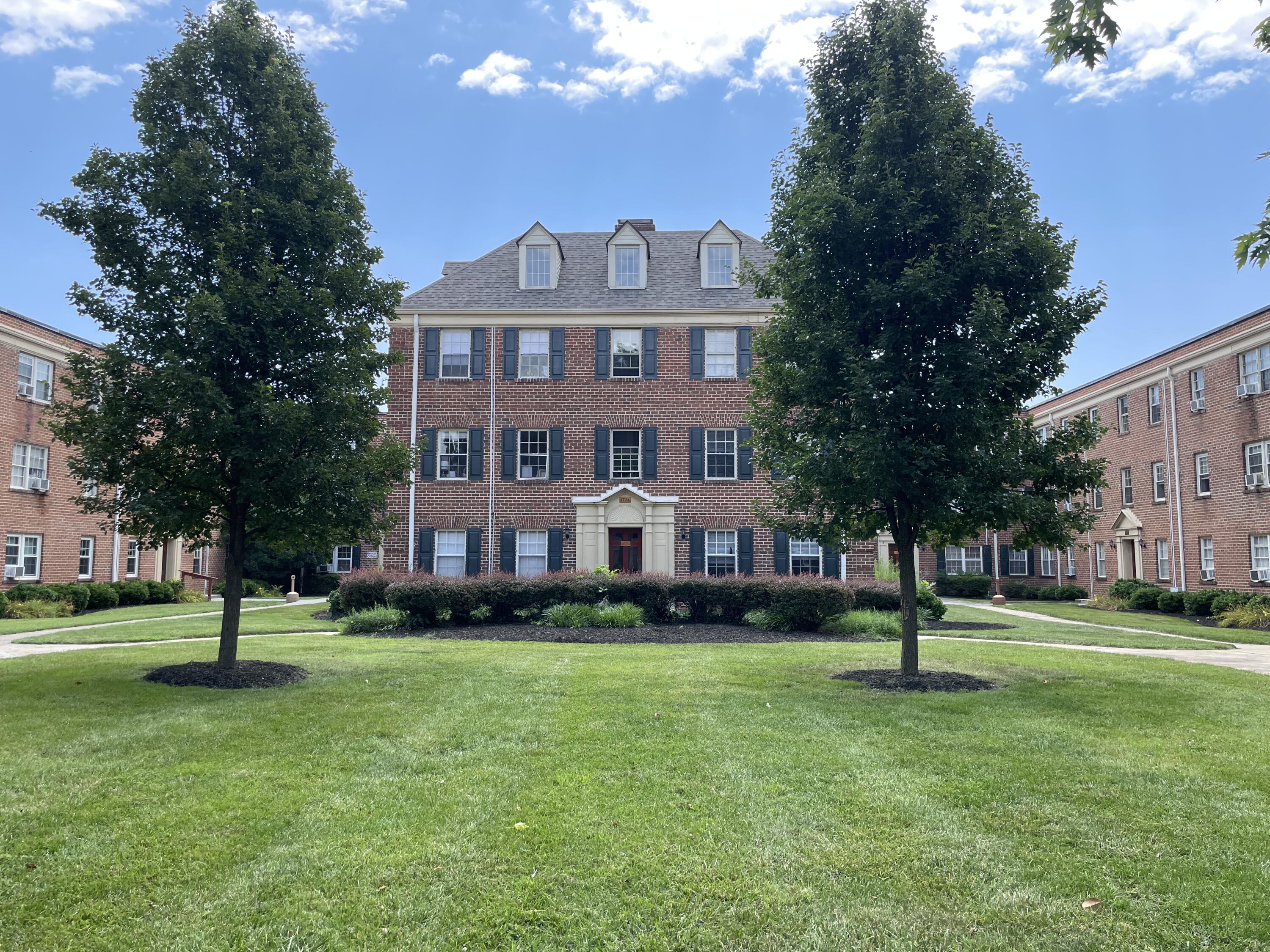 a front view of a building with a garden