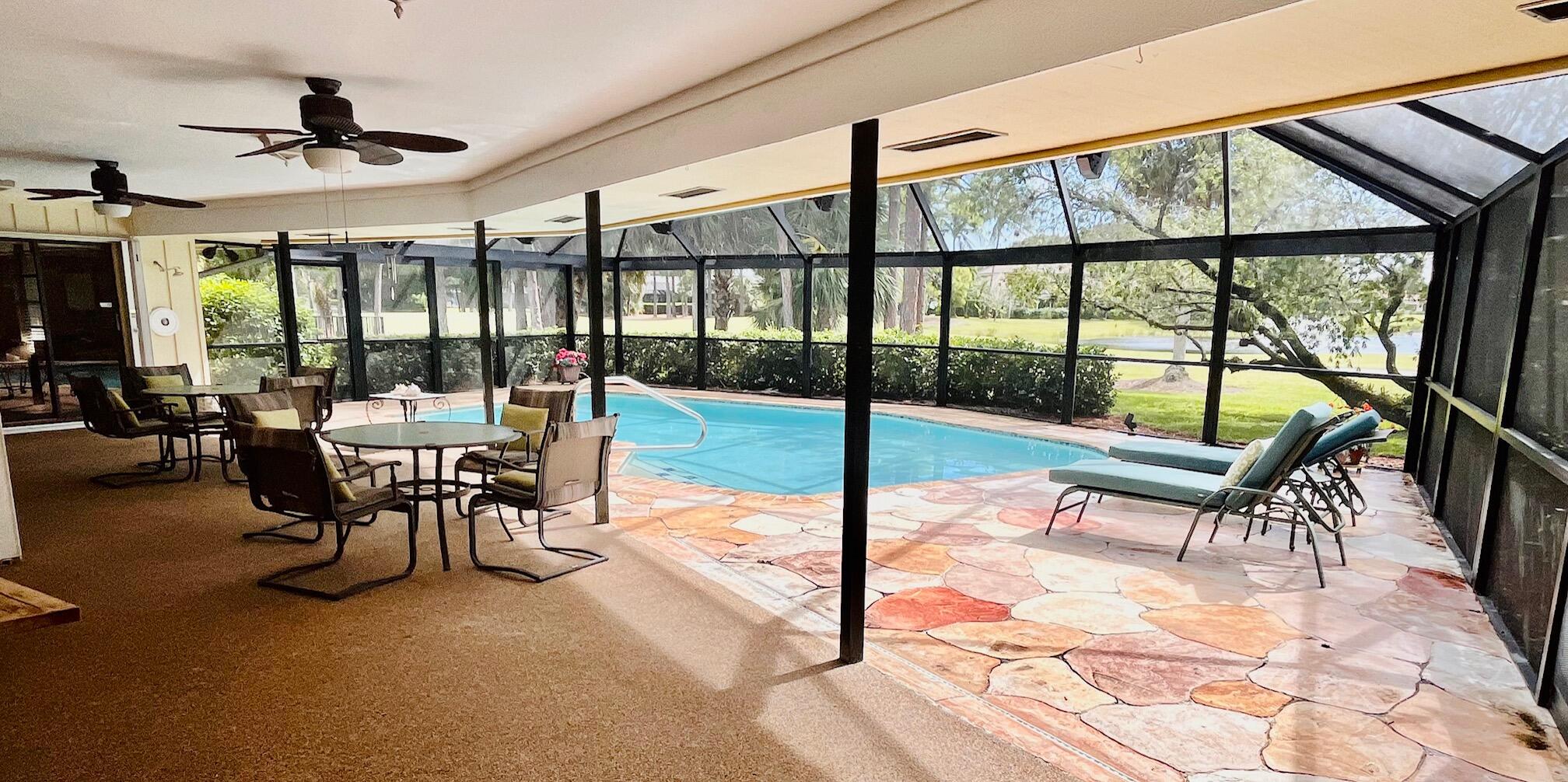 a dining room with furniture water view and a floor to ceiling window