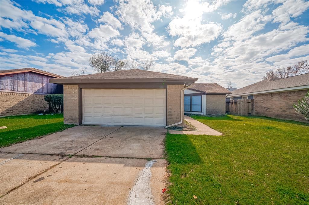 a front view of house with yard and garage