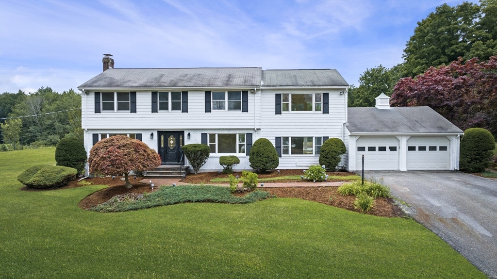 a front view of a house with a garden and plants