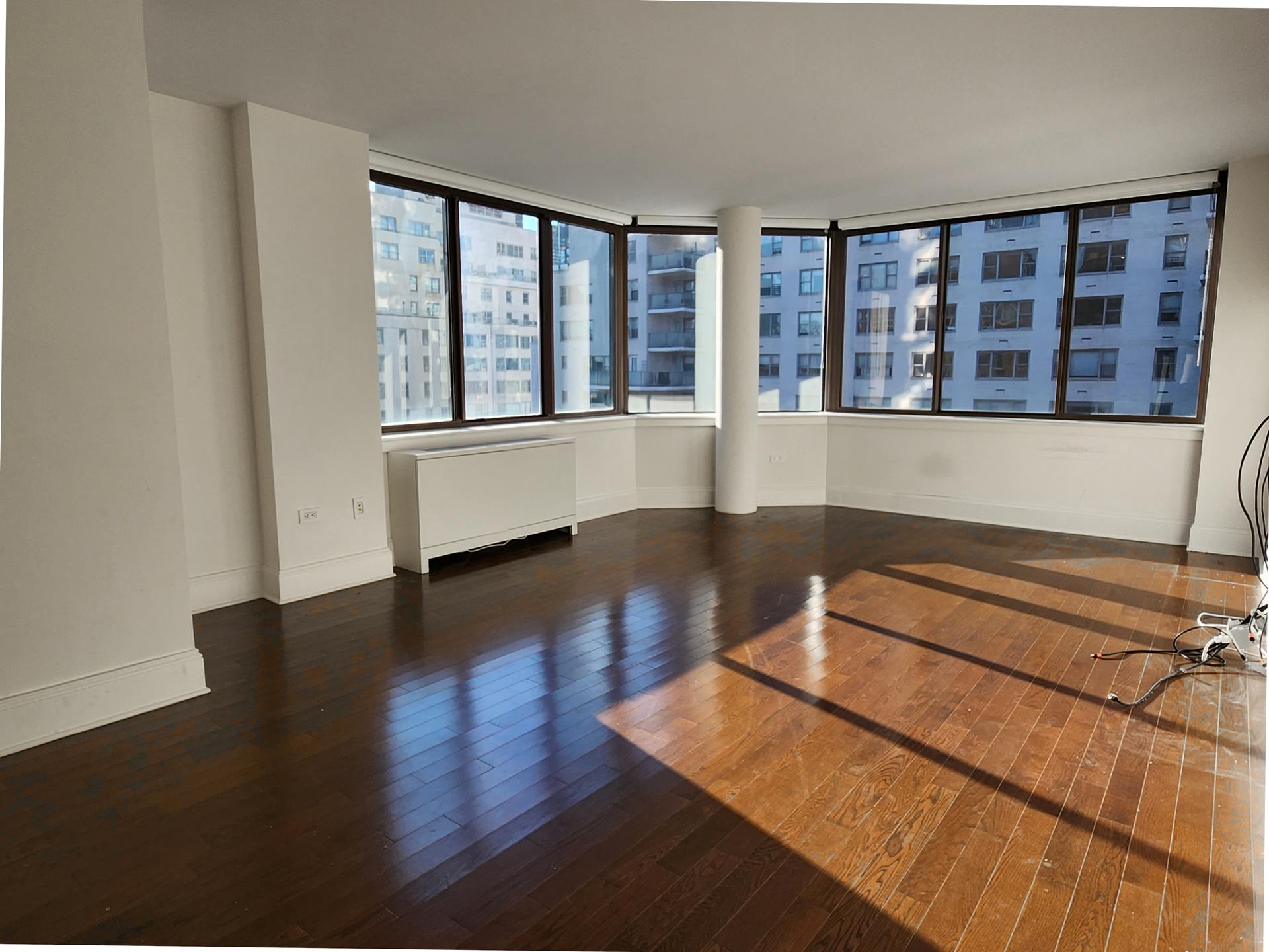 a room with wooden floor and large windows