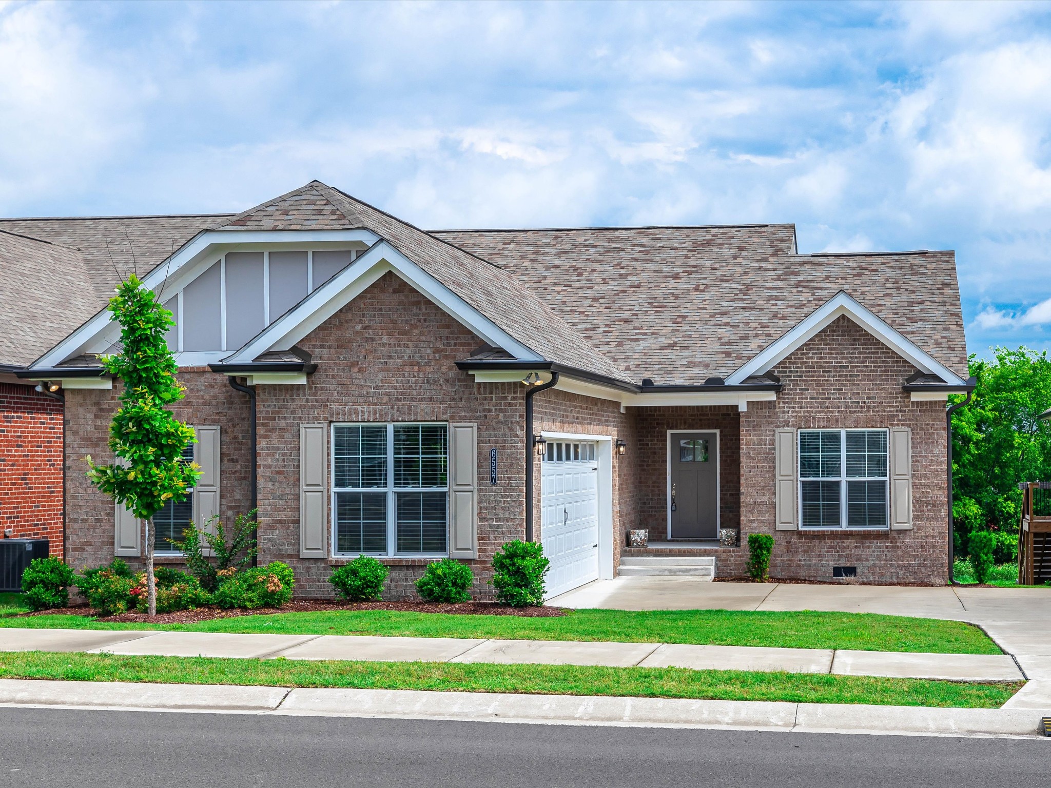 a front view of a house with a yard and potted plants