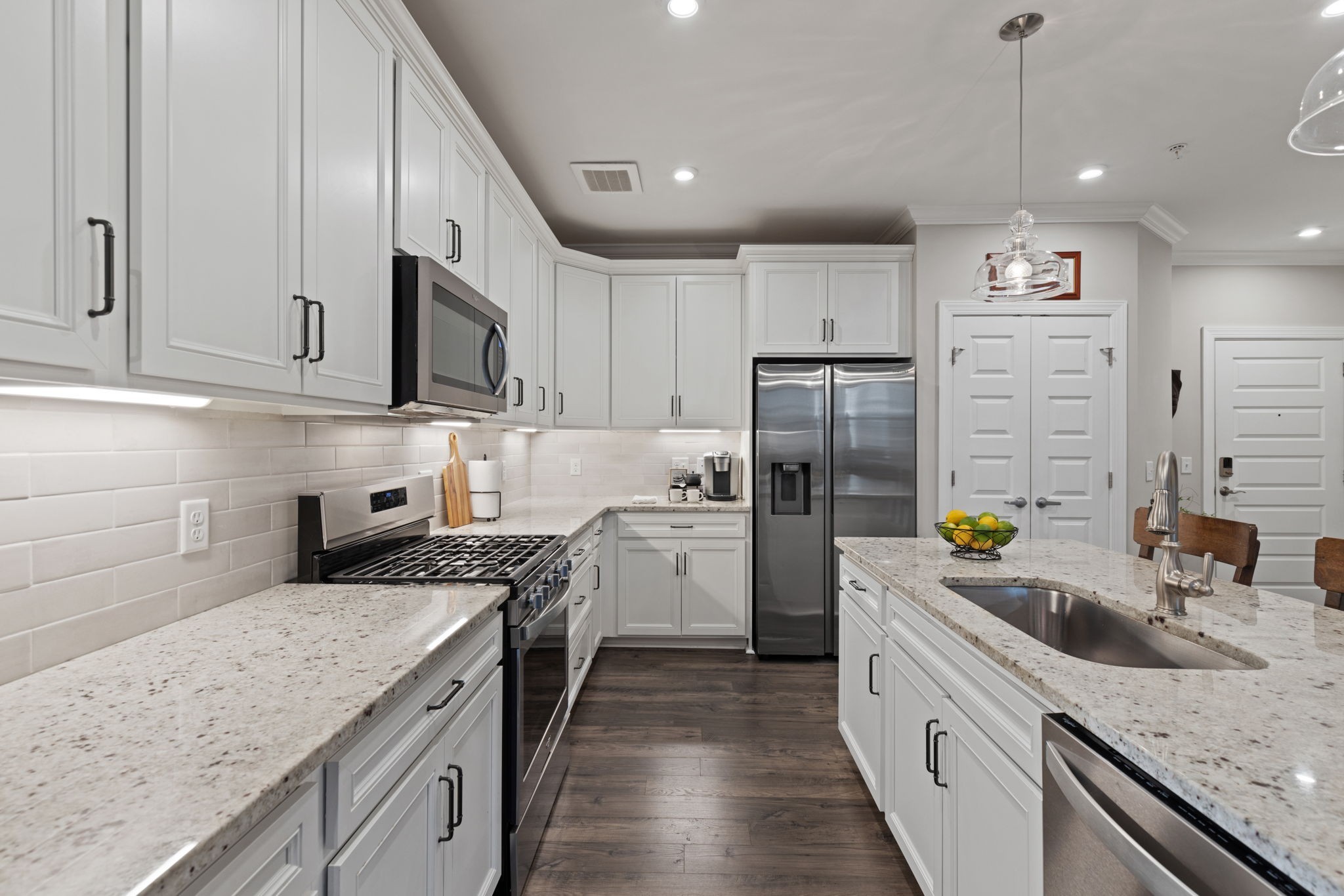 a kitchen with stainless steel appliances granite countertop a sink stove and refrigerator