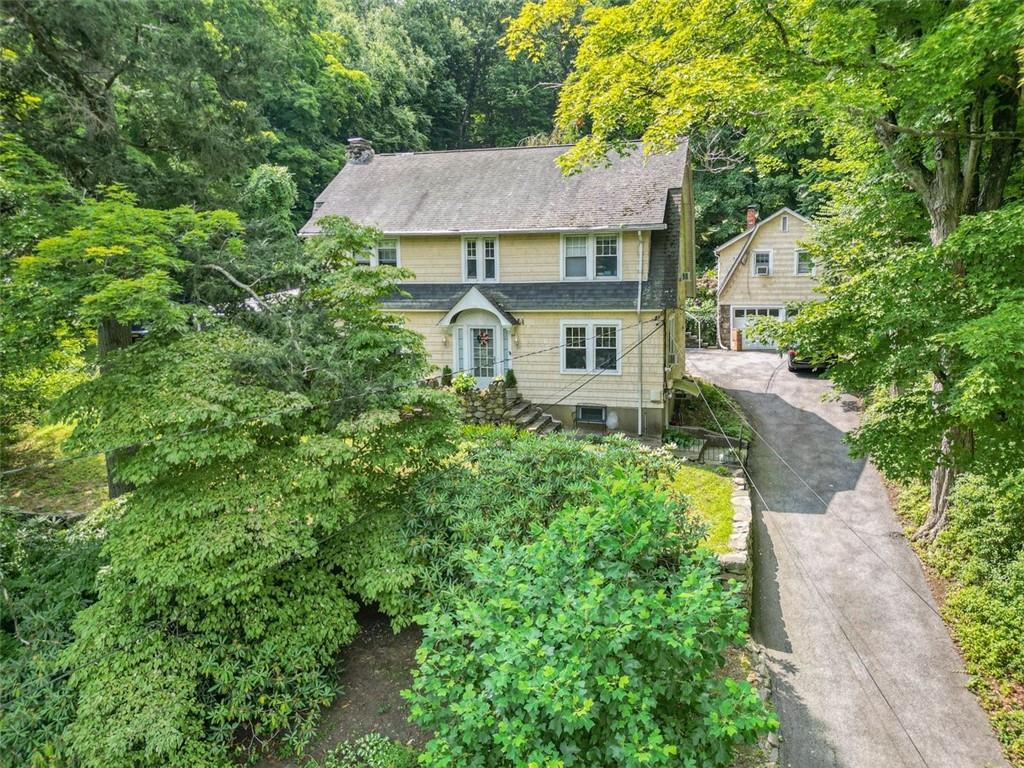 a aerial view of a house with yard and trees in the background