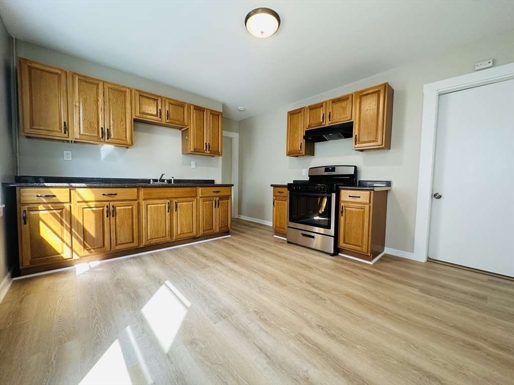 a view of a kitchen with wooden floor and a sink