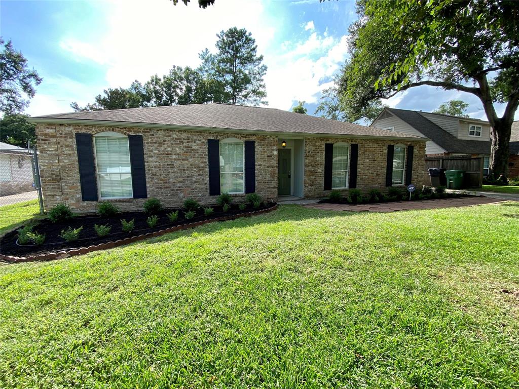 a front view of a house with a yard and trees