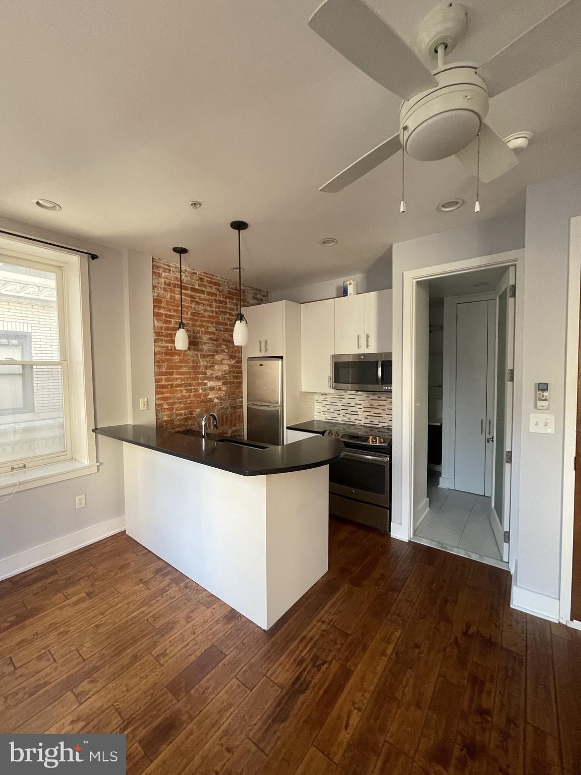 a large kitchen with kitchen island a stove a sink and a refrigerator