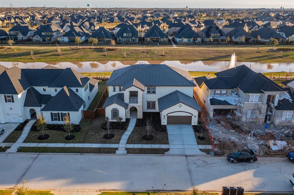 an aerial view of residential houses with outdoor space and lake view