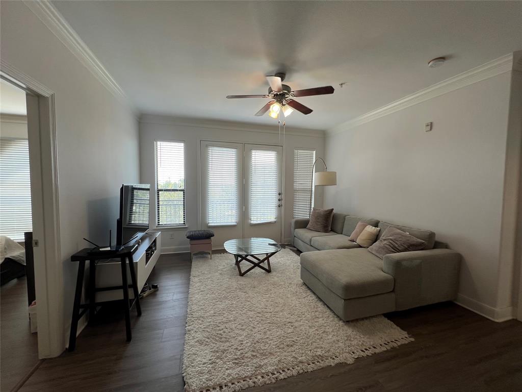 a living room with furniture wooden floor and a window