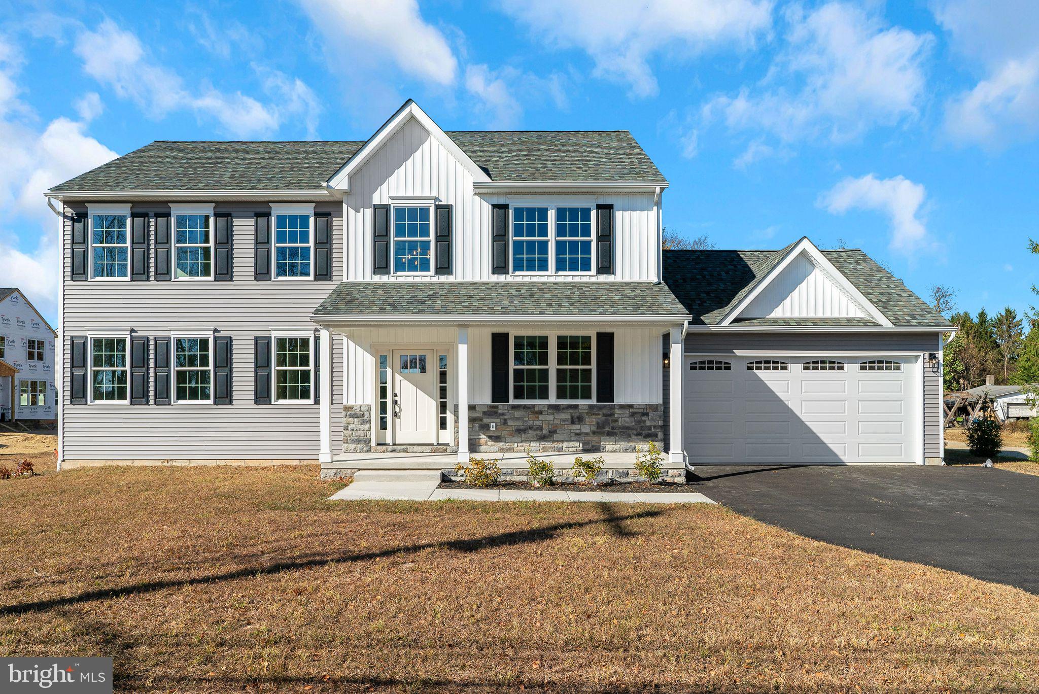 a front view of a house with yard and parking