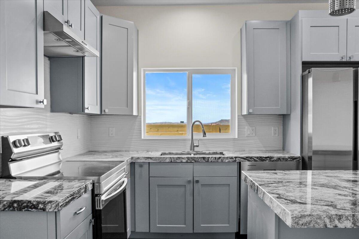 a kitchen with stainless steel appliances granite countertop a sink stove and refrigerator