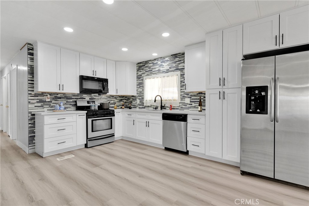 a kitchen with white cabinets and stainless steel appliances