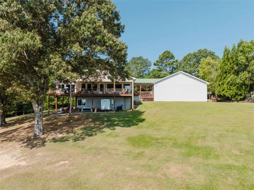 a view of a house with a yard and large tree