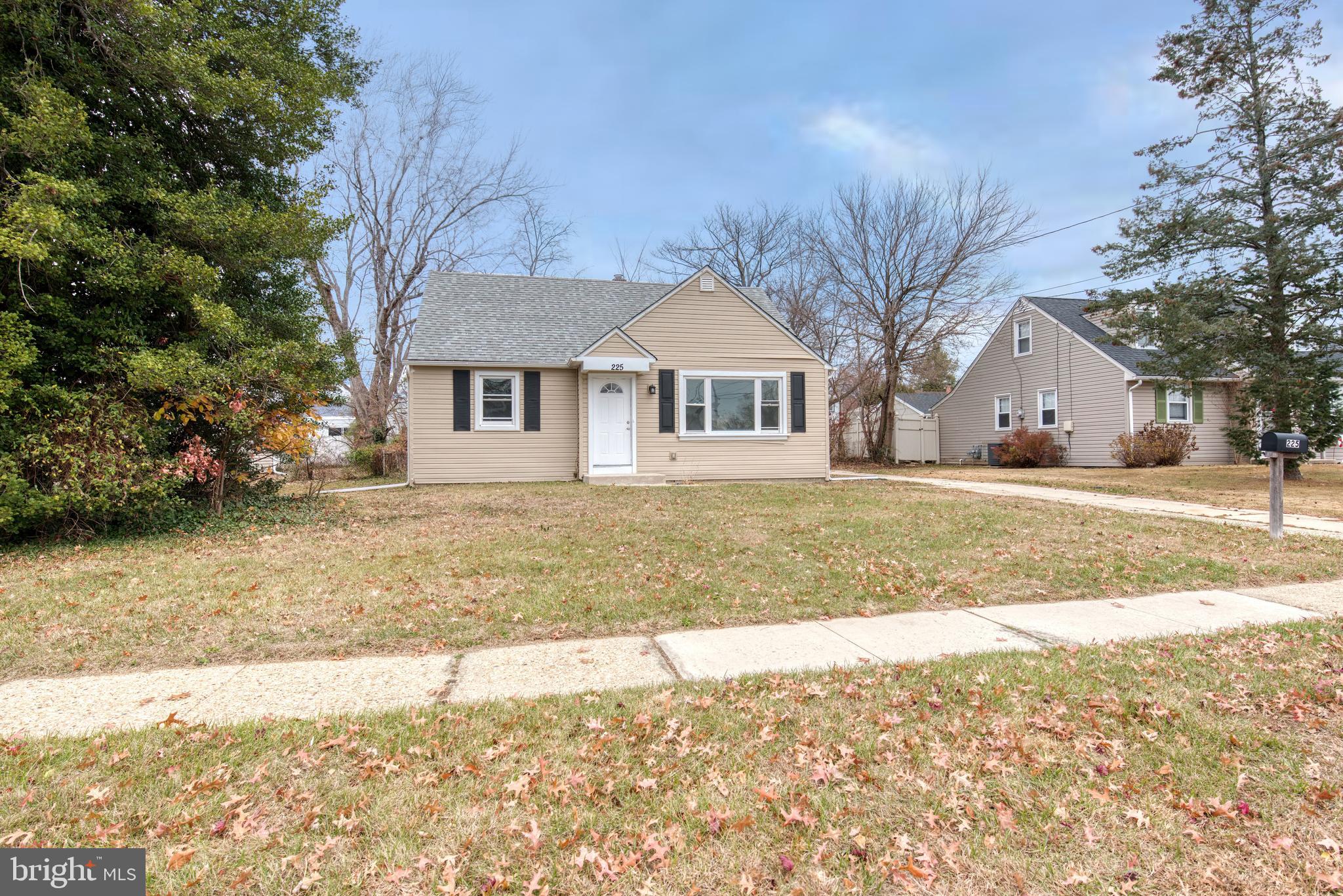 a front view of a house with a yard and trees