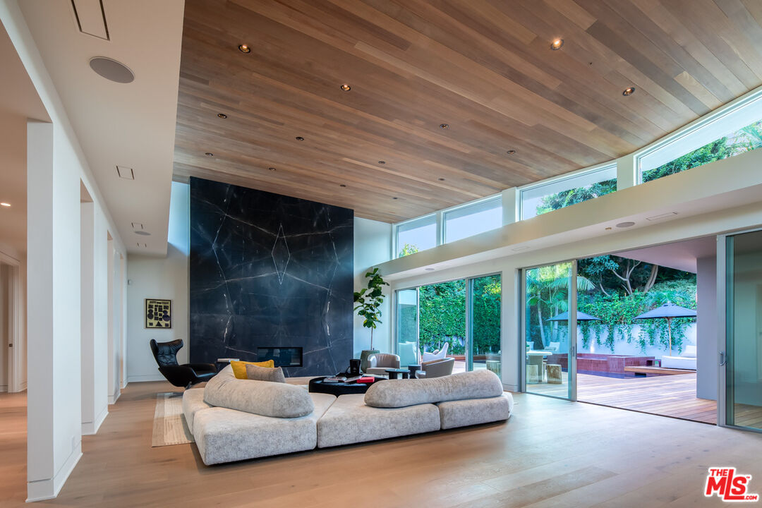 a living room with patio furniture and a garden