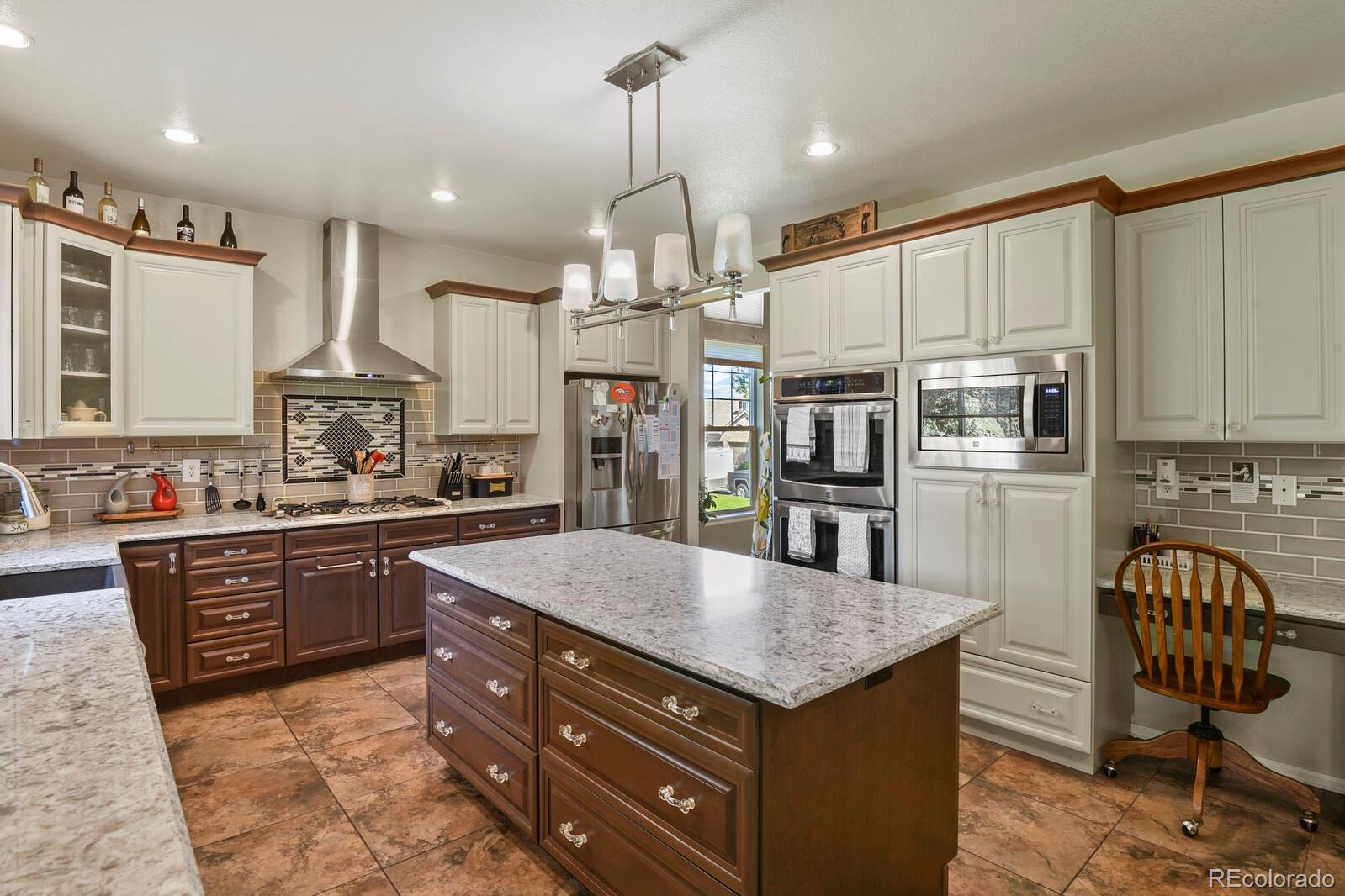 a kitchen with stainless steel appliances granite countertop a sink a stove and a refrigerator