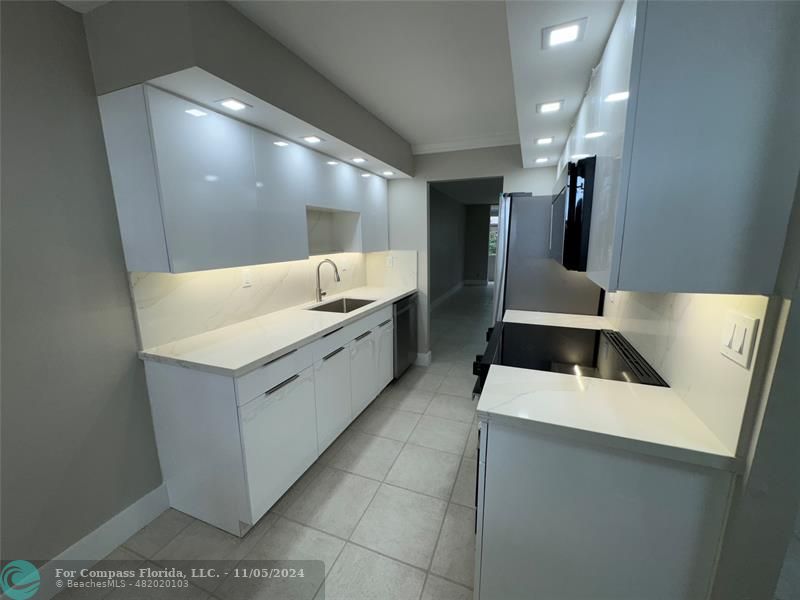 a kitchen with a sink and a stove top oven