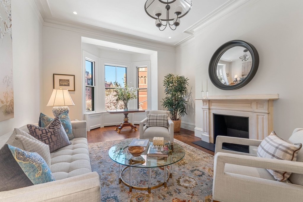 a living room with furniture a fireplace and a large mirror