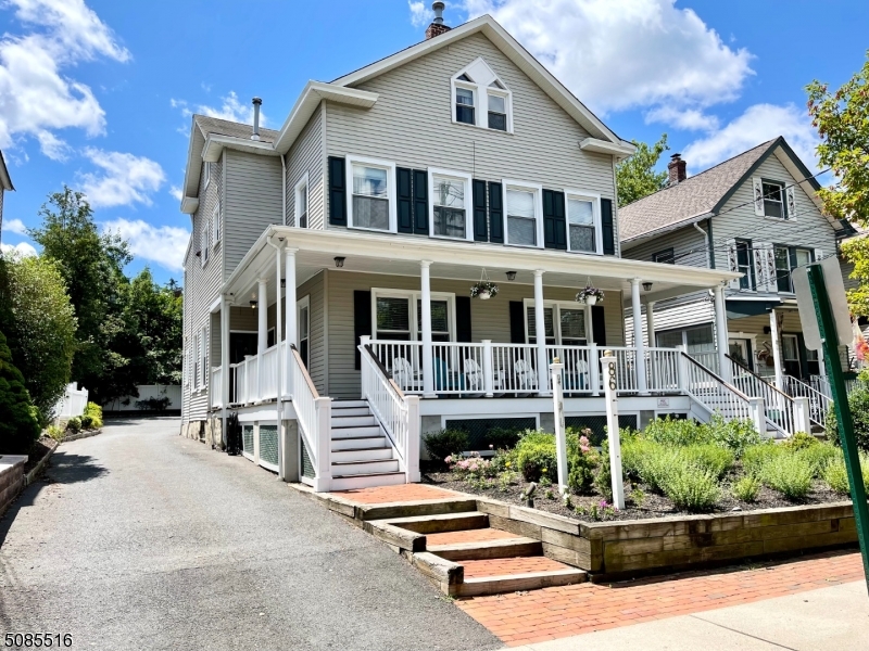 a front view of a house with a yard and potted plants