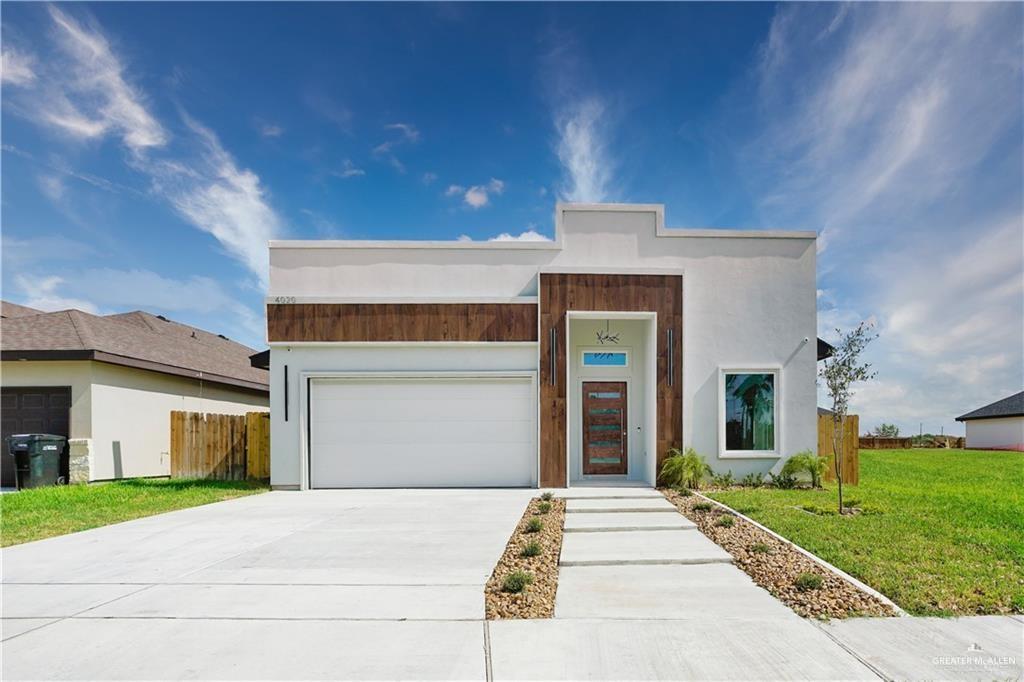 a front view of a house with a garden and garage