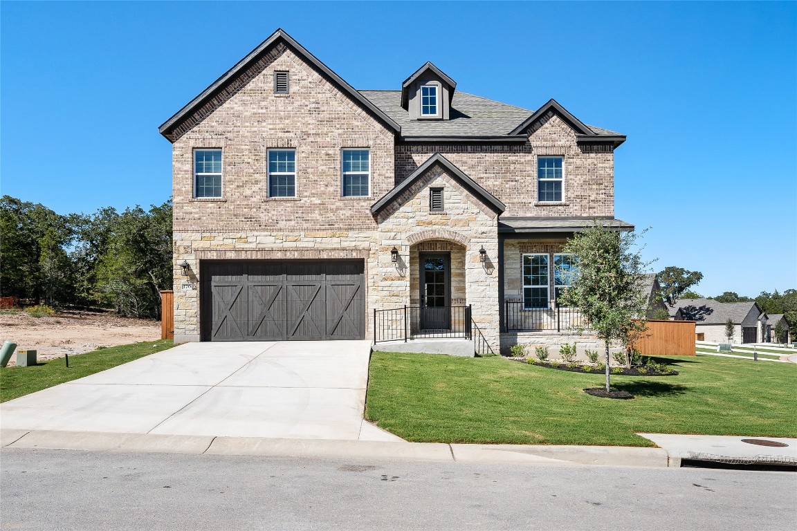 a front view of a house with a yard and garage