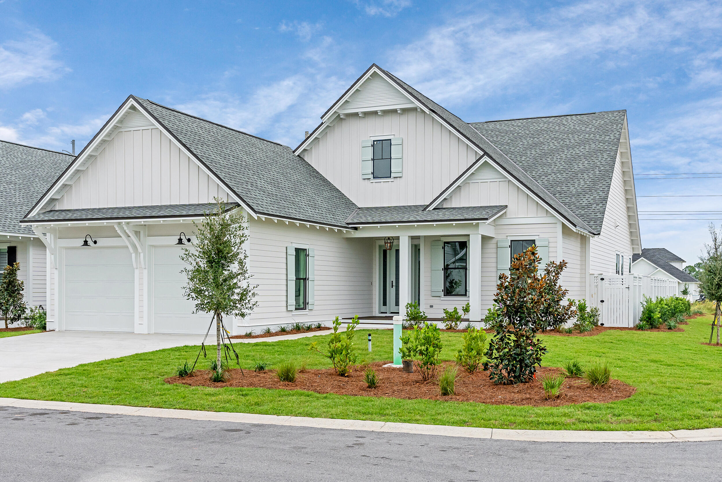 a front view of a house with a yard and potted plants