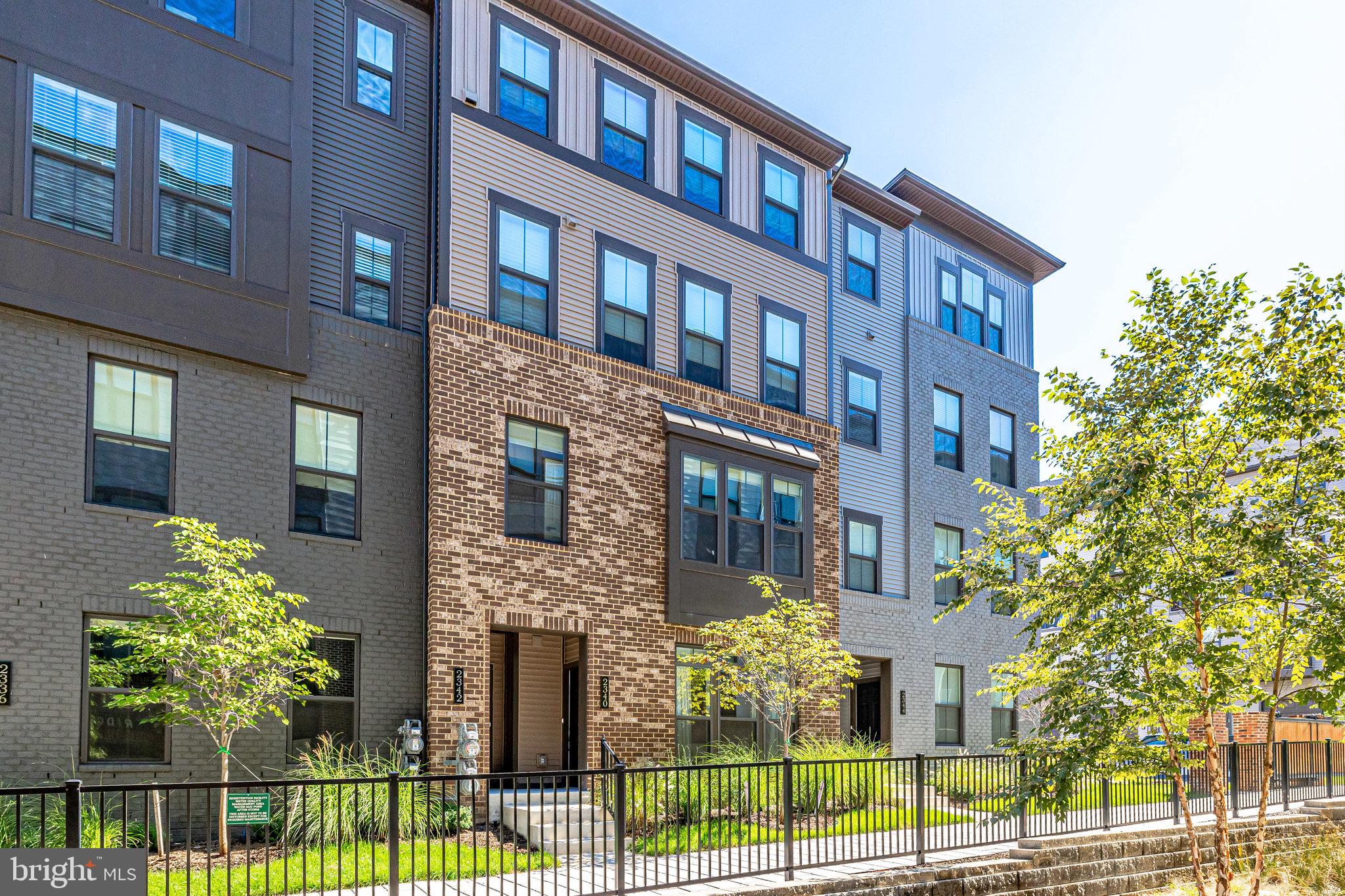 a front view of a multi story residential apartment building with a yard