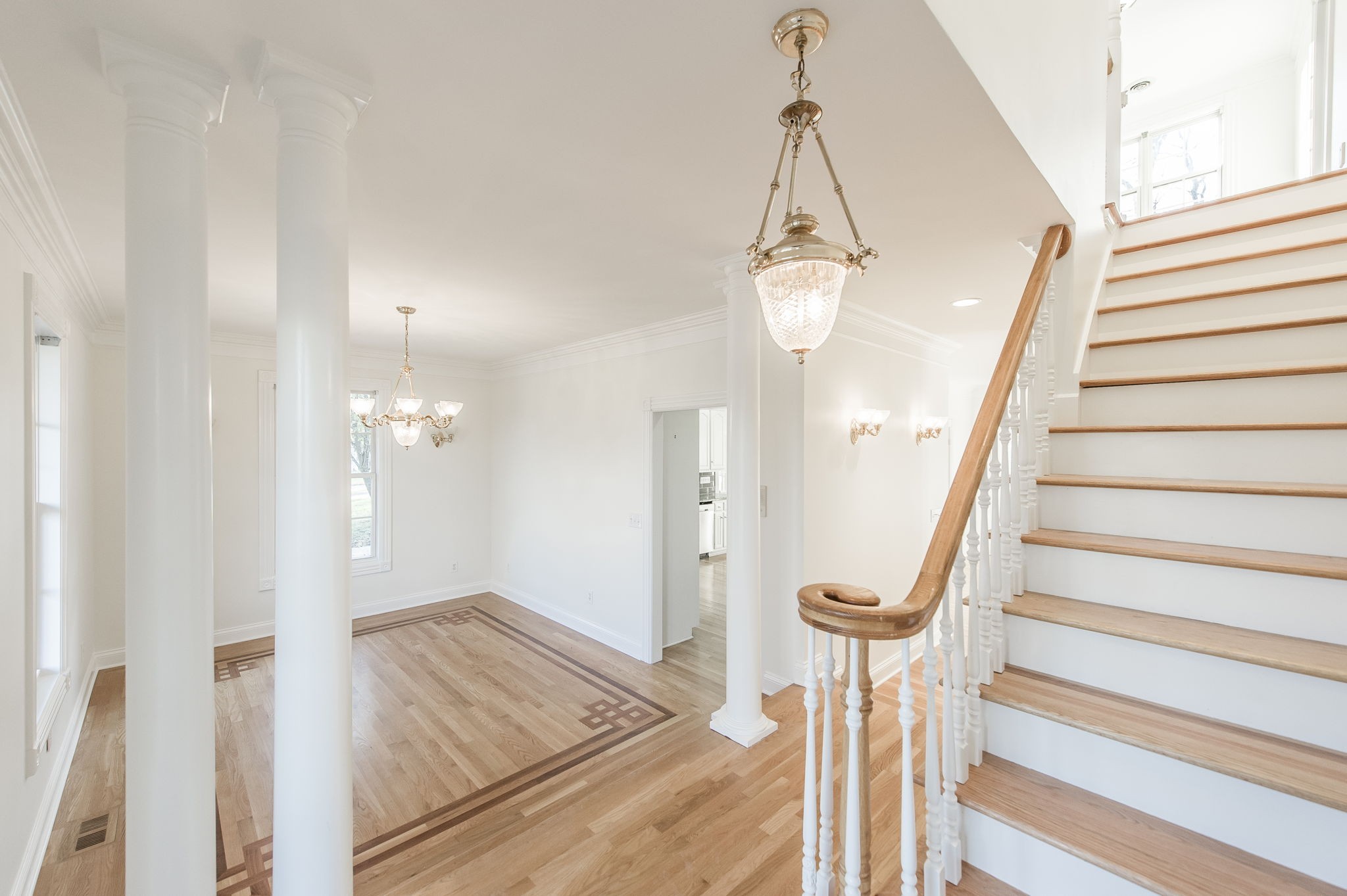 a view of a hallway with wooden floor and staircase