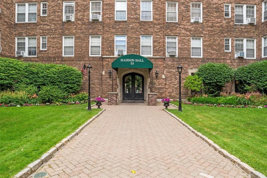 a front view of a brick house with a yard