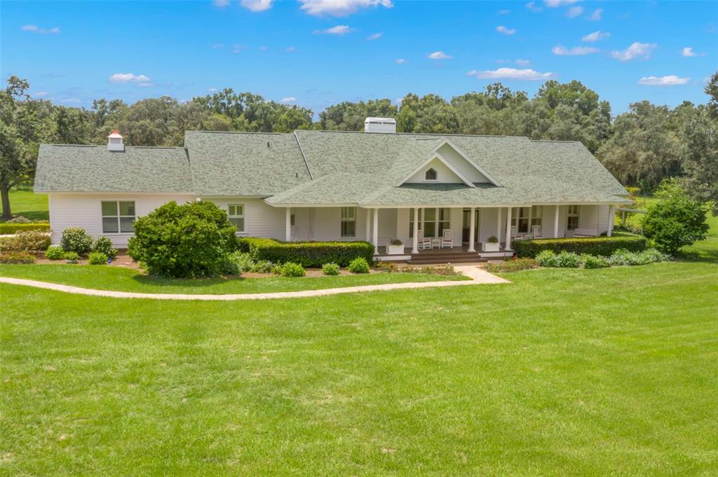 a front view of house with yard swimming pool and outdoor seating