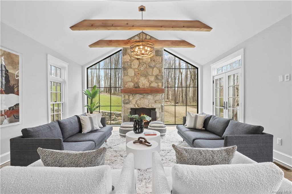 a living room with fireplace furniture and a large window