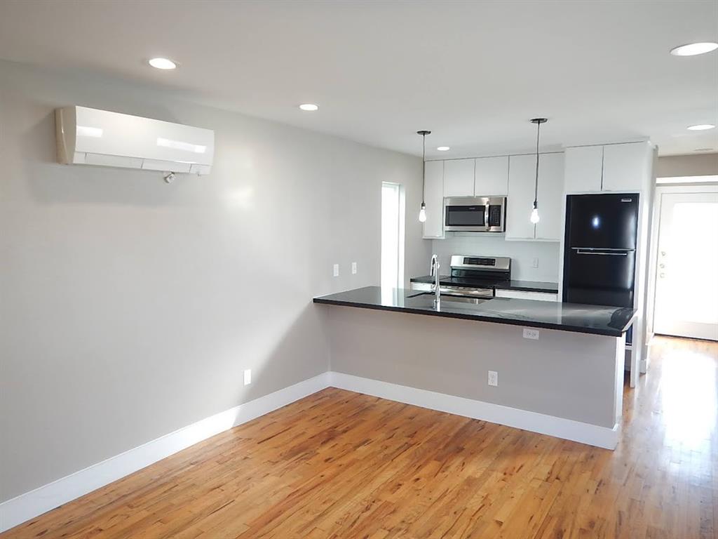 a kitchen with kitchen island a sink a stove a refrigerator and a microwave