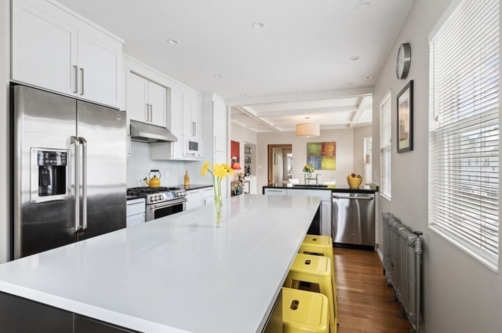 a kitchen with stainless steel appliances granite countertop a refrigerator a stove and a sink