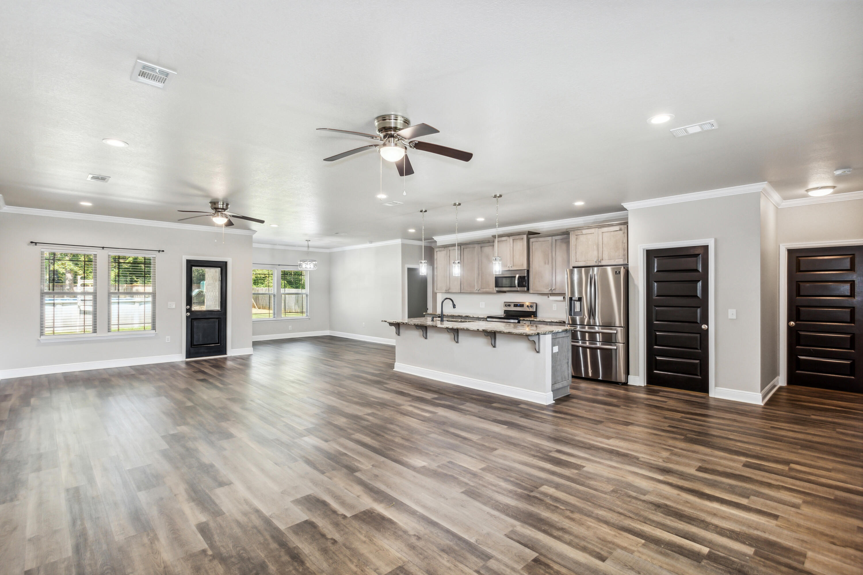 an open kitchen with white cabinets and wooden floor