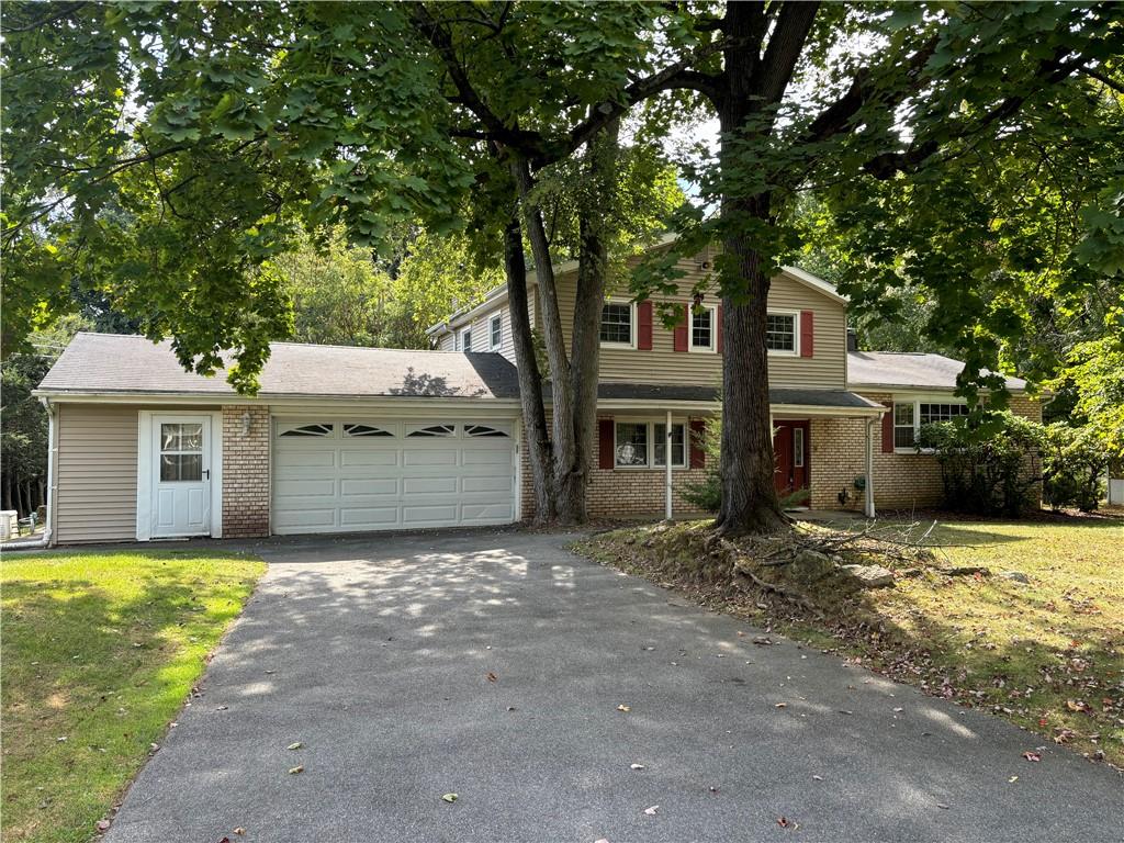 View of front facade featuring a garage and a front lawn