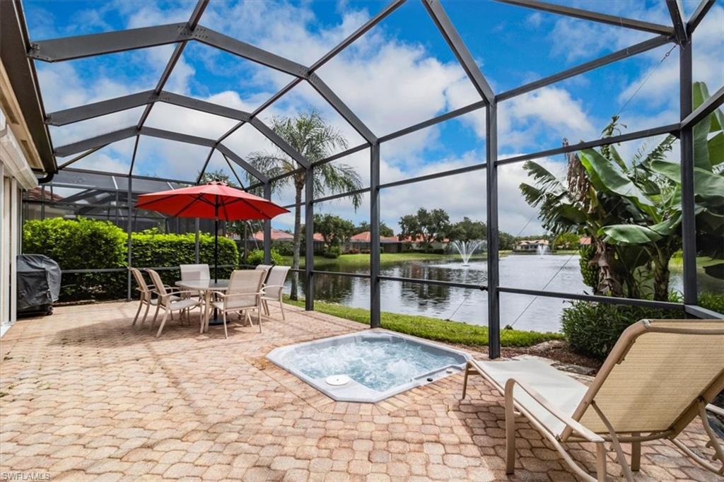 Lanai featuring a spa and water view