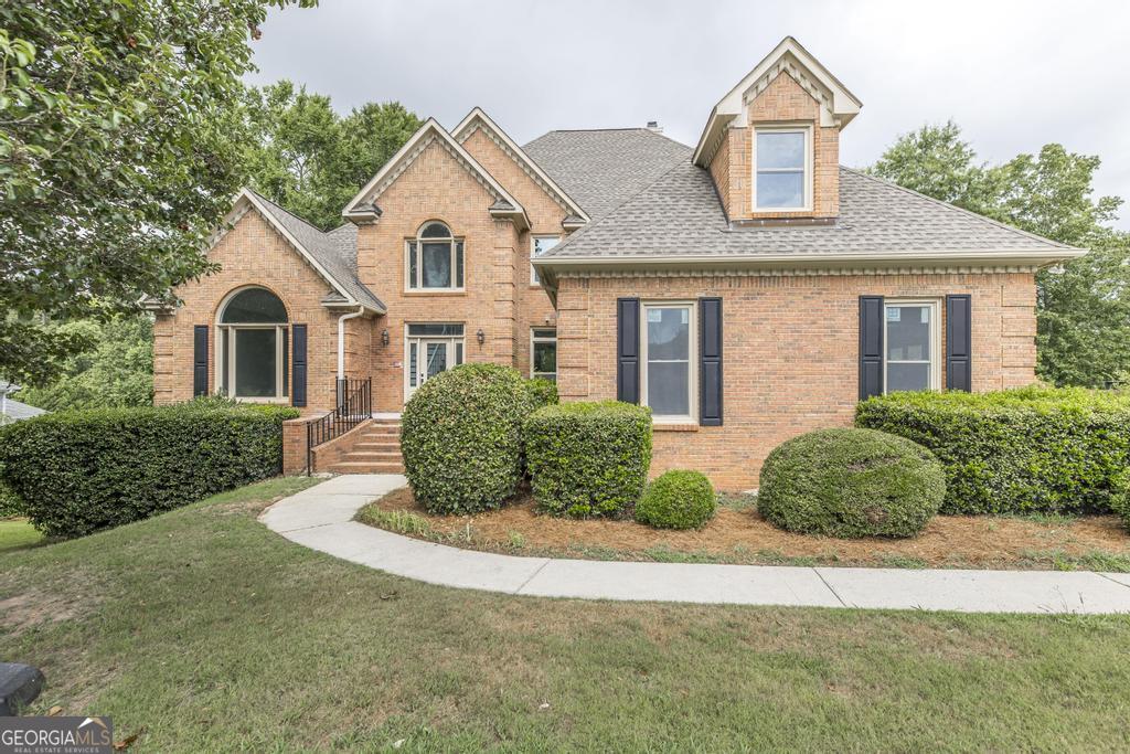 a front view of a house with a garden