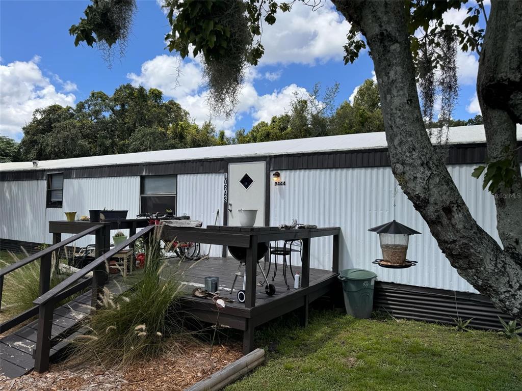 a view of a house with a wooden deck and a yard