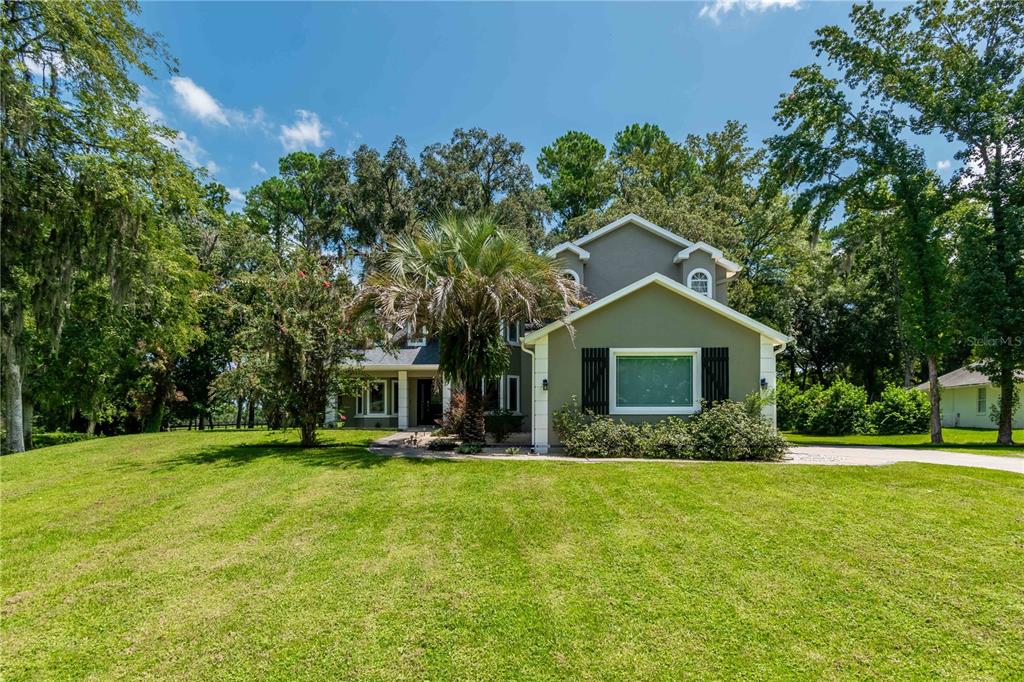 a front view of house with yard and green space