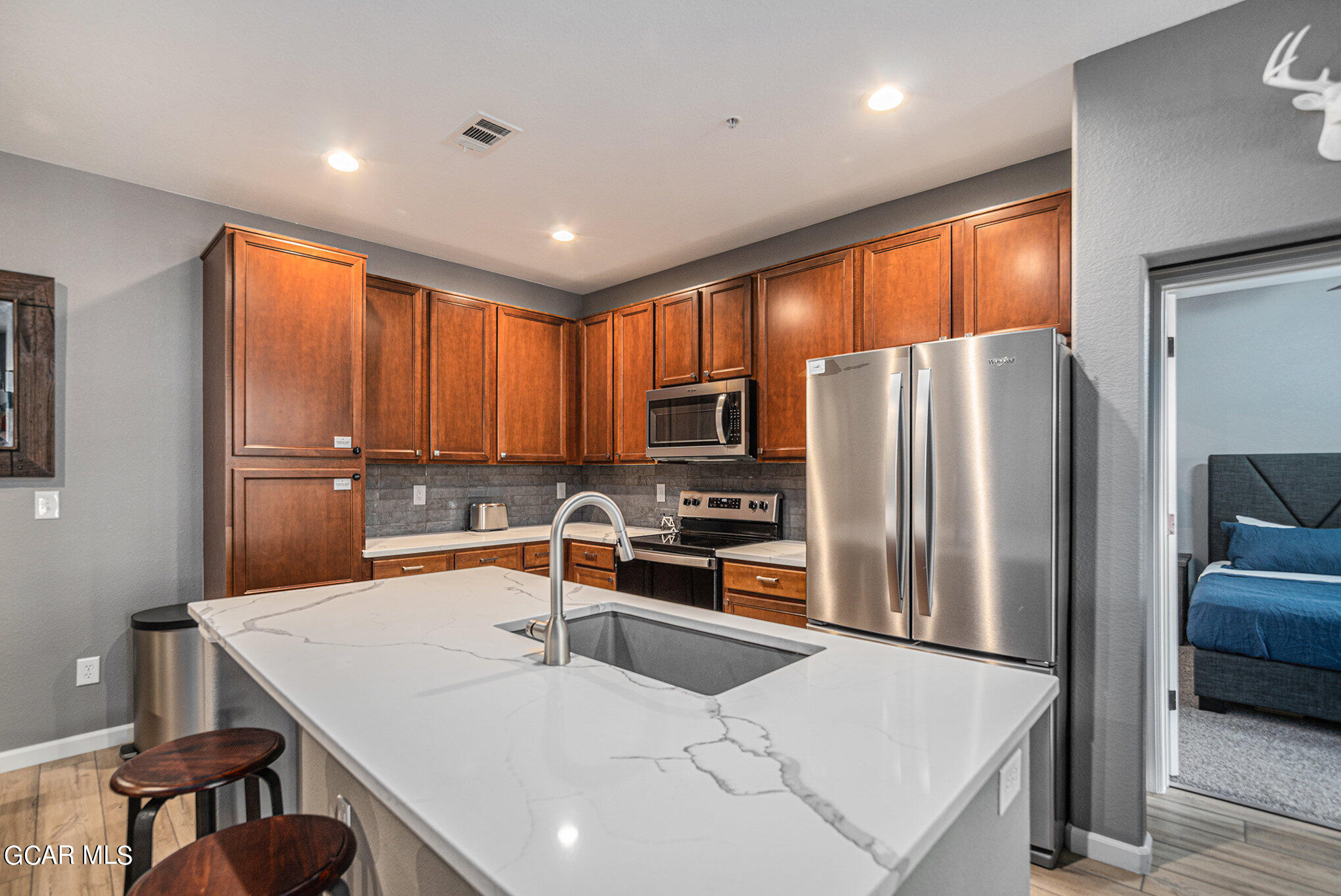 a kitchen with stainless steel appliances a refrigerator a sink a stove a table and chairs