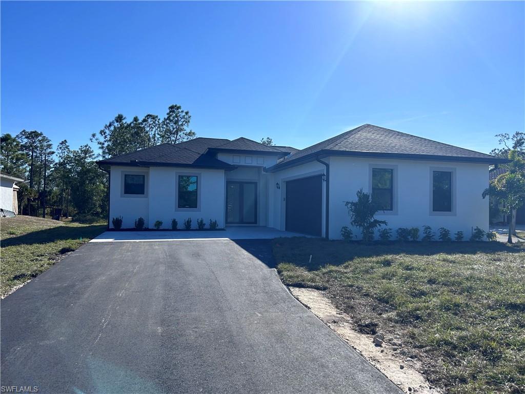 View of front of property featuring a garage and a front lawn