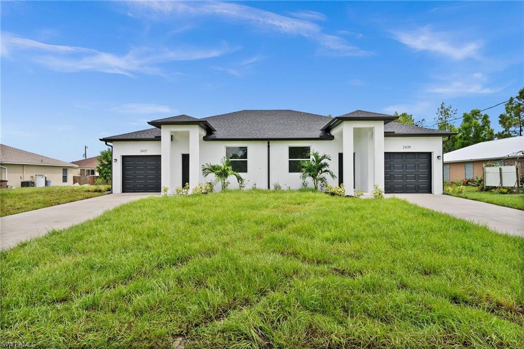 a front view of a house with a yard and garage