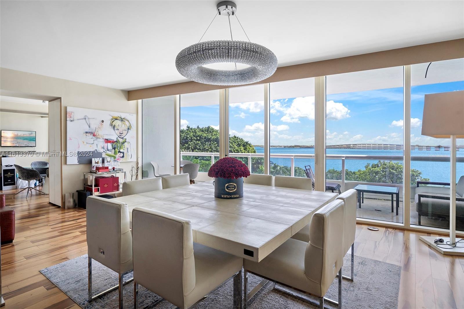 a dining room with furniture a chandelier and wooden floor