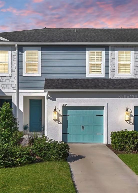 a front view of a house with a yard and garage