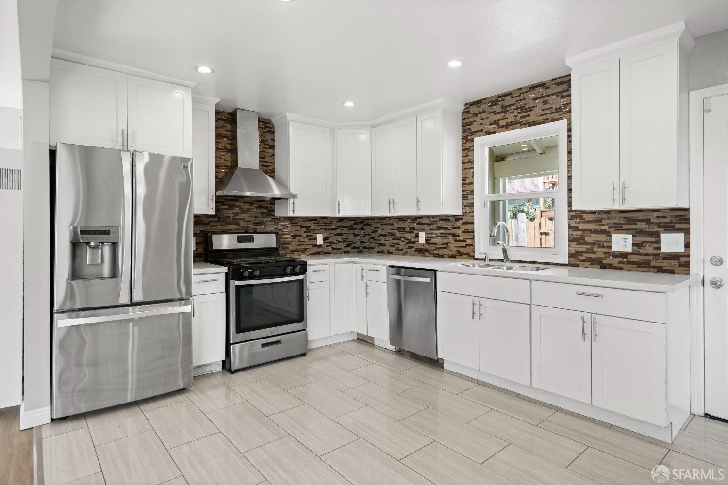 a kitchen with granite countertop white cabinets and stainless steel appliances