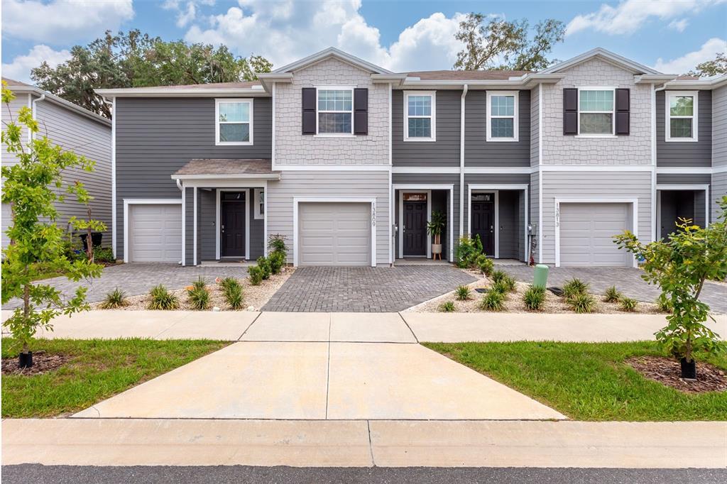 a front view of house with yard garage and outdoor seating