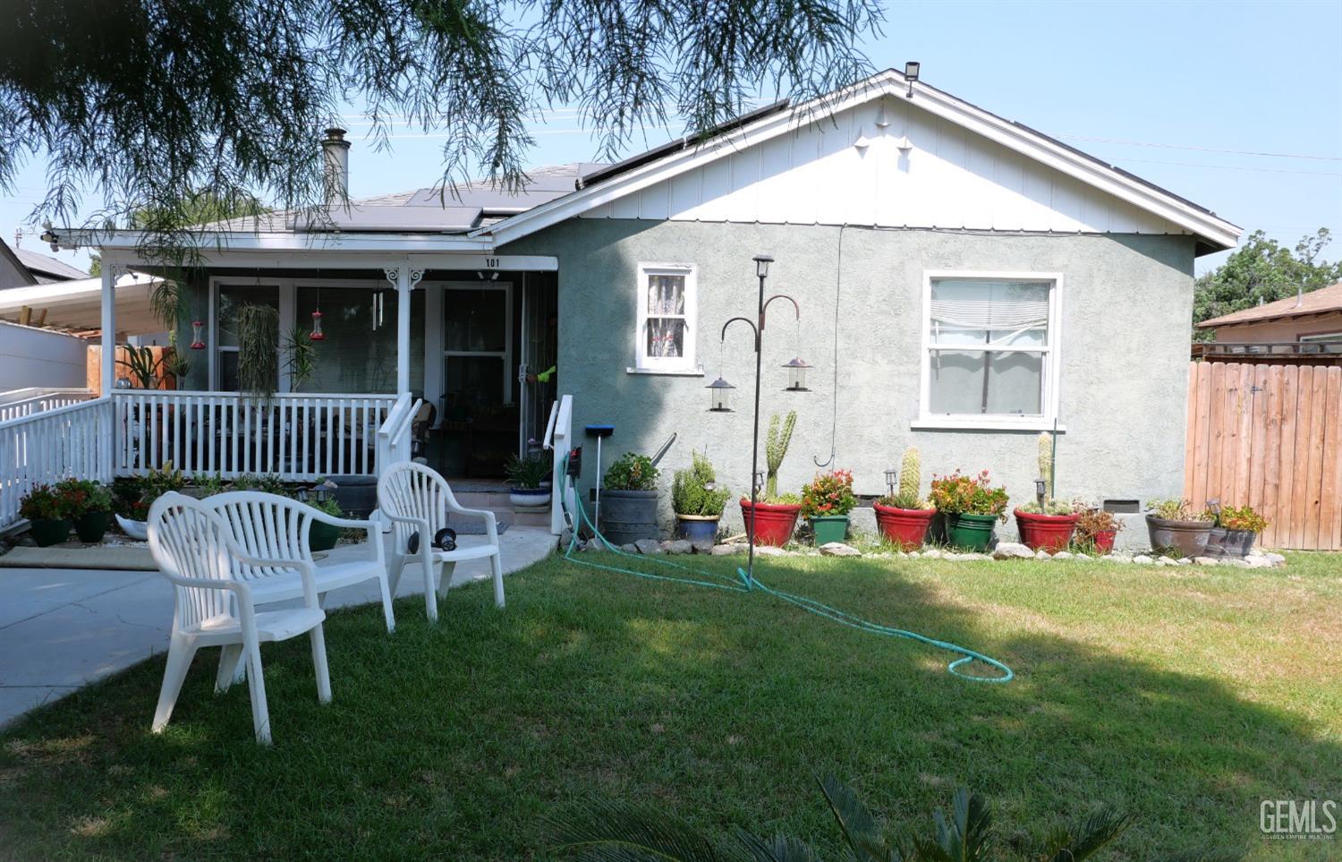 a view of a chair and table in backyard of the house