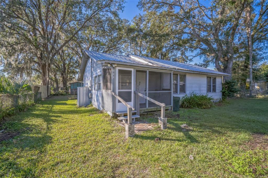 a view of a house with backyard and a tree