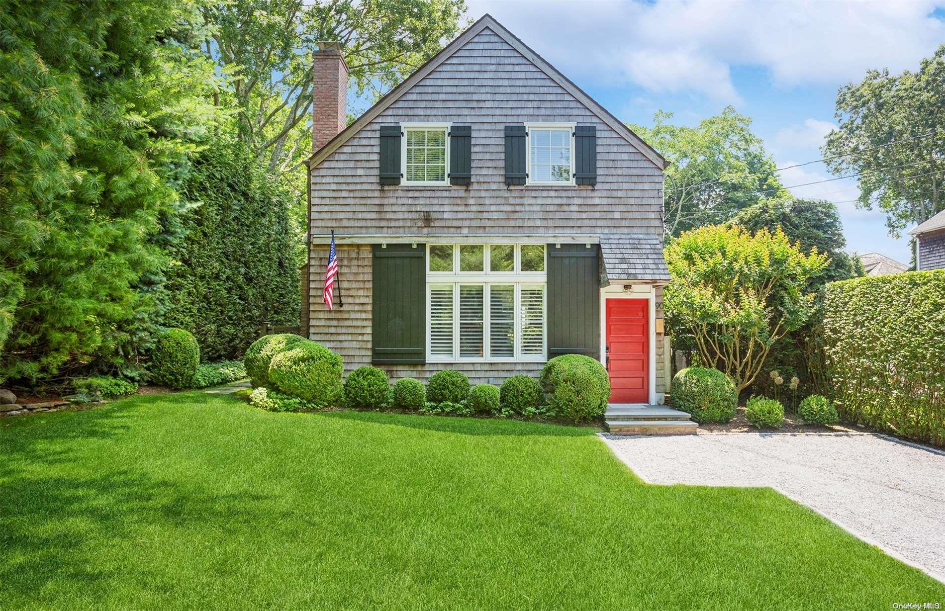 a front view of a house with a yard and plants